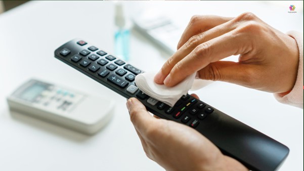 Cleaning a flat-screen TV with a microfiber cloth to remove dust and smudges without scratching